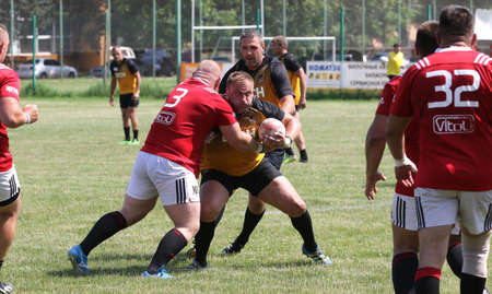Odessa, Ukraine - June 23, 2021: Odessa National Team CREDO (red) - OLYMP-Kharkiv (yellow) in rugby 7s. Sharp aggressive fight of male rugby players for ball. Dynamic play on green grass of stadiumのeditorial素材
