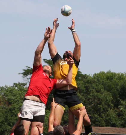 Odessa, Ukraine - June 23, 2021: Odessa National Team CREDO (red) - OLYMP-Kharkiv (yellow) in rugby 7s. Sharp aggressive fight of male rugby players for ball. Dynamic play on green grass of stadiumのeditorial素材