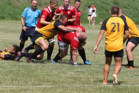 Odessa, Ukraine - June 23, 2021: Odessa National Team CREDO (red) - OLYMP-Kharkiv (yellow) in rugby 7s. Sharp aggressive fight of male rugby players for ball. Dynamic play on green grass of stadiumのeditorial素材