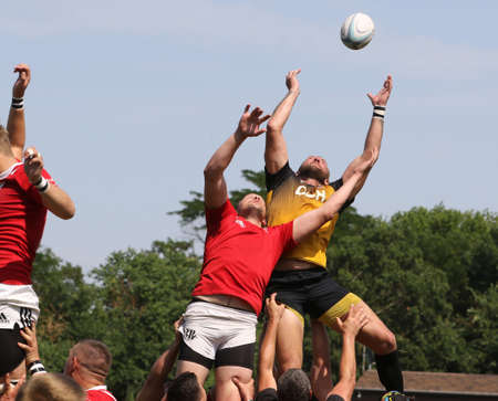 Odessa, Ukraine - June 23, 2021: Odessa National Team CREDO (red) - OLYMP-Kharkiv (yellow) in rugby 7s. Sharp aggressive fight of male rugby players for ball. Dynamic play on green grass of stadiumのeditorial素材