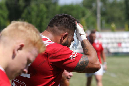 Odessa, Ukraine - June 23, 2021: Odessa National Team CREDO (red) - OLYMP-Kharkiv (yellow) in rugby 7s. Sharp aggressive fight of male rugby players for ball. Dynamic play on green grass of stadiumのeditorial素材