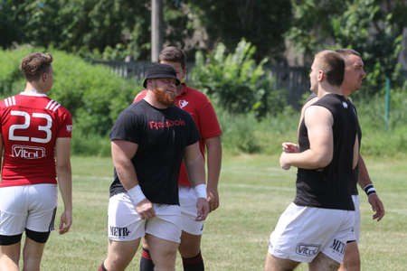 Odessa, Ukraine - June 23, 2021: Odessa National Team CREDO (red) - OLYMP-Kharkiv (yellow) in rugby 7s. Sharp aggressive fight of male rugby players for ball. Dynamic play on green grass of stadiumのeditorial素材