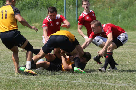 Odessa, Ukraine - June 23, 2021: Odessa National Team CREDO (red) - OLYMP-Kharkiv (yellow) in rugby 7s. Sharp aggressive fight of male rugby players for ball. Dynamic play on green grass of stadiumのeditorial素材