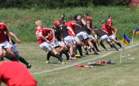 Odessa, Ukraine - June 23, 2021: Odessa National Team CREDO (red) - OLYMP-Kharkiv (yellow) in rugby 7s. Sharp aggressive fight of male rugby players for ball. Dynamic play on green grass of stadiumのeditorial素材