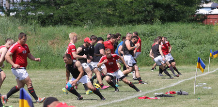 Odessa, Ukraine - June 23, 2021: Odessa National Team CREDO (red) - OLYMP-Kharkiv (yellow) in rugby 7s. Sharp aggressive fight of male rugby players for ball. Dynamic play on green grass of stadiumのeditorial素材