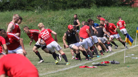 Odessa, Ukraine - June 23, 2021: Odessa National Team CREDO (red) - OLYMP-Kharkiv (yellow) in rugby 7s. Sharp aggressive fight of male rugby players for ball. Dynamic play on green grass of stadiumのeditorial素材