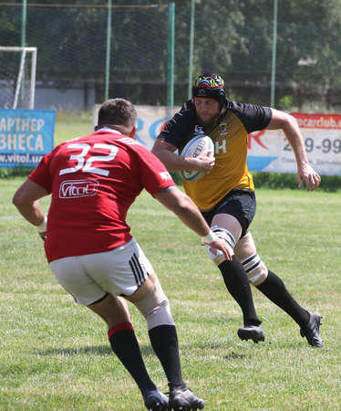 Odessa, Ukraine - June 23, 2021: Odessa National Team CREDO (red) - OLYMP-Kharkiv (yellow) in rugby 7s. Sharp aggressive fight of male rugby players for ball. Dynamic play on green grass of stadiumのeditorial素材