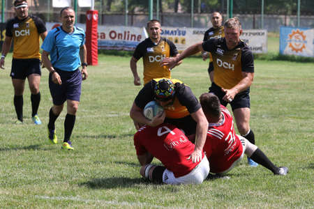 Odessa, Ukraine - June 23, 2021: Odessa National Team CREDO (red) - OLYMP-Kharkiv (yellow) in rugby 7s. Sharp aggressive fight of male rugby players for ball. Dynamic play on green grass of stadiumのeditorial素材