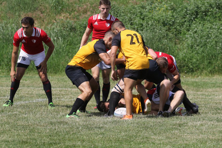 Odessa, Ukraine - June 23, 2021: Odessa National Team CREDO (red) - OLYMP-Kharkiv (yellow) in rugby 7s. Sharp aggressive fight of male rugby players for ball. Dynamic play on green grass of stadiumのeditorial素材