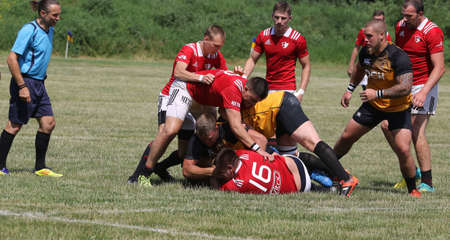 Odessa, Ukraine - June 23, 2021: Odessa National Team CREDO (red) - OLYMP-Kharkiv (yellow) in rugby 7s. Sharp aggressive fight of male rugby players for ball. Dynamic play on green grass of stadiumのeditorial素材