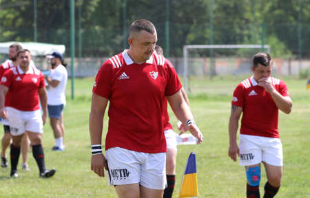Odessa, Ukraine - June 23, 2021: Odessa National Team CREDO (red) - OLYMP-Kharkiv (yellow) in rugby 7s. Sharp aggressive fight of male rugby players for ball. Dynamic play on green grass of stadiumのeditorial素材