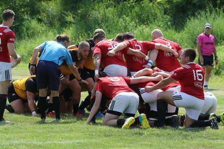 Odessa, Ukraine - June 23, 2021: Odessa National Team CREDO (red) - OLYMP-Kharkiv (yellow) in rugby 7s. Sharp aggressive fight of male rugby players for ball. Dynamic play on green grass of stadiumのeditorial素材