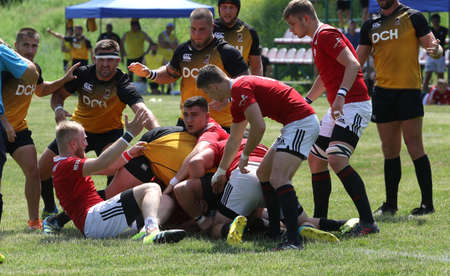Odessa, Ukraine - June 23, 2021: Odessa National Team CREDO (red) - OLYMP-Kharkiv (yellow) in rugby 7s. Sharp aggressive fight of male rugby players for ball. Dynamic play on green grass of stadiumのeditorial素材