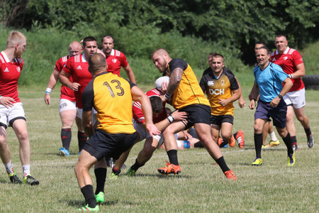 Odessa, Ukraine - June 23, 2021: Odessa National Team CREDO (red) - OLYMP-Kharkiv (yellow) in rugby 7s. Sharp aggressive fight of male rugby players for ball. Dynamic play on green grass of stadiumのeditorial素材