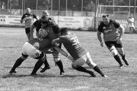 Odessa, Ukraine - June 23, 2021: Odessa National Team CREDO (red) - OLYMP-Kharkiv (yellow) in rugby 7s. Sharp aggressive fight of male rugby players for ball. Dynamic play on green grass of stadiumのeditorial素材