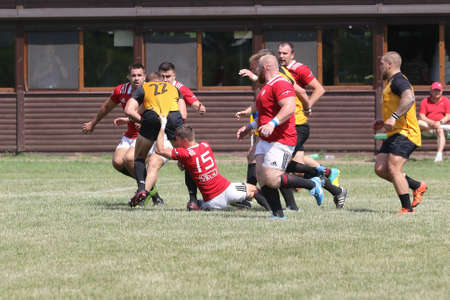Odessa, Ukraine - June 23, 2021: Odessa National Team CREDO (red) - OLYMP-Kharkiv (yellow) in rugby 7s. Sharp aggressive fight of male rugby players for ball. Dynamic play on green grass of stadiumのeditorial素材