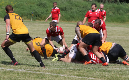 Odessa, Ukraine - June 23, 2021: Odessa National Team CREDO (red) - OLYMP-Kharkiv (yellow) in rugby 7s. Sharp aggressive fight of male rugby players for ball. Dynamic play on green grass of stadiumのeditorial素材