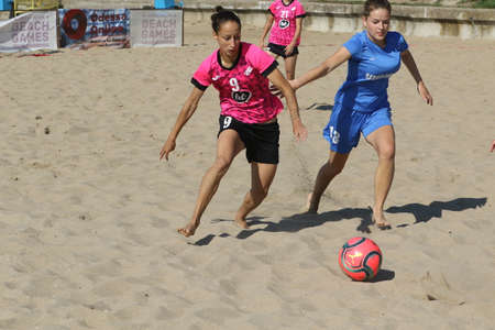 ODESSA, UKRAINE July 8, 2021: Ukrainian Beach Soccer Women's Cup. The girl's footballers are desperately playing beach soccer on sand of sea city beach on a hot sunny day. Women's soccer on sandのeditorial素材