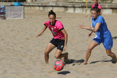 ODESSA, UKRAINE July 8, 2021: Ukrainian Beach Soccer Women's Cup. The girl's footballers are desperately playing beach soccer on sand of sea city beach on a hot sunny day. Women's soccer on sandのeditorial素材