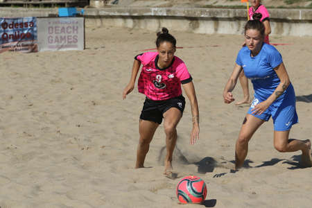 ODESSA, UKRAINE July 8, 2021: Ukrainian Beach Soccer Women's Cup. The girl's footballers are desperately playing beach soccer on sand of sea city beach on a hot sunny day. Women's soccer on sandのeditorial素材