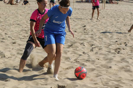 ODESSA, UKRAINE July 8, 2021: Ukrainian Beach Soccer Women's Cup. The girl's footballers are desperately playing beach soccer on sand of sea city beach on a hot sunny day. Women's soccer on sandのeditorial素材