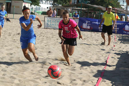 ODESSA, UKRAINE July 8, 2021: Ukrainian Beach Soccer Women's Cup. The girl's footballers are desperately playing beach soccer on sand of sea city beach on a hot sunny day. Women's soccer on sandのeditorial素材
