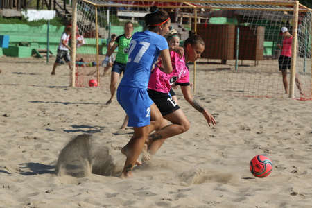 ODESSA, UKRAINE July 8, 2021: Ukrainian Beach Soccer Women's Cup. The girl's footballers are desperately playing beach soccer on sand of sea city beach on a hot sunny day. Women's soccer on sandのeditorial素材