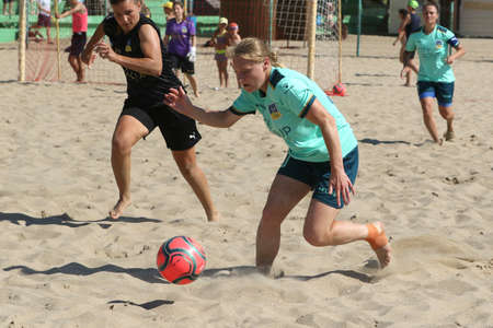 ODESSA, UKRAINE July 8, 2021: Ukrainian Beach Soccer Women's Cup. The girl's footballers are desperately playing beach soccer on sand of sea city beach on a hot sunny day. Women's soccer on sandのeditorial素材