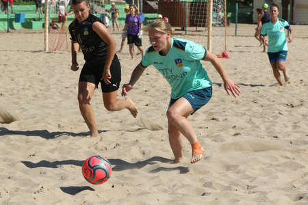 ODESSA, UKRAINE July 8, 2021: Ukrainian Beach Soccer Women's Cup. The girl's footballers are desperately playing beach soccer on sand of sea city beach on a hot sunny day. Women's soccer on sandのeditorial素材