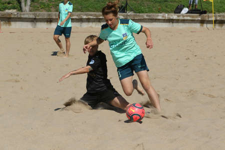 ODESSA, UKRAINE July 8, 2021: Ukrainian Beach Soccer Women's Cup. The girl's footballers are desperately playing beach soccer on sand of sea city beach on a hot sunny day. Women's soccer on sandのeditorial素材