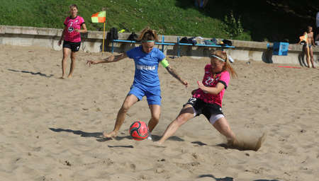 ODESSA, UKRAINE July 8, 2021: Ukrainian Beach Soccer Women's Cup. The girl's footballers are desperately playing beach soccer on sand of sea city beach on a hot sunny day. Women's soccer on sandのeditorial素材