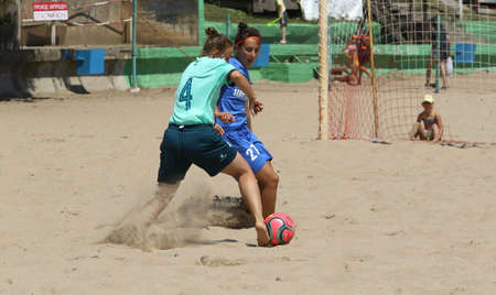 ODESSA, UKRAINE July 8, 2021: Ukrainian Beach Soccer Women's Cup. The girl's footballers are desperately playing beach soccer on sand of sea city beach on a hot sunny day. Women's soccer on sandのeditorial素材