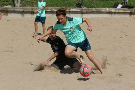ODESSA, UKRAINE July 8, 2021: Ukrainian Beach Soccer Women's Cup. The girl's footballers are desperately playing beach soccer on sand of sea city beach on a hot sunny day. Women's soccer on sandのeditorial素材