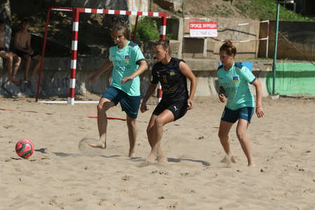 ODESSA, UKRAINE July 8, 2021: Ukrainian Beach Soccer Women's Cup. The girl's footballers are desperately playing beach soccer on sand of sea city beach on a hot sunny day. Women's soccer on sandのeditorial素材