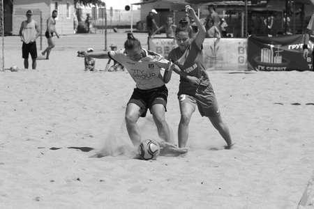 ODESSA, UKRAINE July 8, 2021: Ukrainian Beach Soccer Women's Cup. The girl's footballers are desperately playing beach soccer on sand of sea city beach on a hot sunny day. Women's soccer on sandのeditorial素材