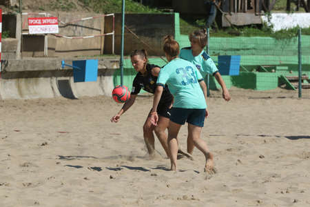 ODESSA, UKRAINE July 8, 2021: Ukrainian Beach Soccer Women's Cup. The girl's footballers are desperately playing beach soccer on sand of sea city beach on a hot sunny day. Women's soccer on sandのeditorial素材