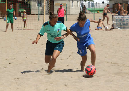 ODESSA, UKRAINE July 8, 2021: Ukrainian Beach Soccer Women's Cup. The girl's footballers are desperately playing beach soccer on sand of sea city beach on a hot sunny day. Women's soccer on sandのeditorial素材