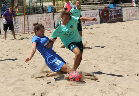 ODESSA, UKRAINE July 8, 2021: Ukrainian Beach Soccer Women's Cup. The girl's footballers are desperately playing beach soccer on sand of sea city beach on a hot sunny day. Women's soccer on sandのeditorial素材