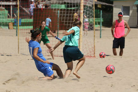 ODESSA, UKRAINE July 8, 2021: Ukrainian Beach Soccer Women's Cup. The girl's footballers are desperately playing beach soccer on sand of sea city beach on a hot sunny day. Women's soccer on sandのeditorial素材