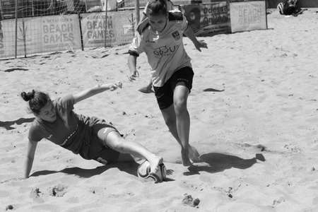 ODESSA, UKRAINE July 8, 2021: Ukrainian Beach Soccer Women's Cup. The girl's footballers are desperately playing beach soccer on sand of sea city beach on a hot sunny day. Women's soccer on sandのeditorial素材