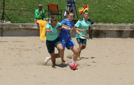 ODESSA, UKRAINE July 8, 2021: Ukrainian Beach Soccer Women's Cup. The girl's footballers are desperately playing beach soccer on sand of sea city beach on a hot sunny day. Women's soccer on sandのeditorial素材