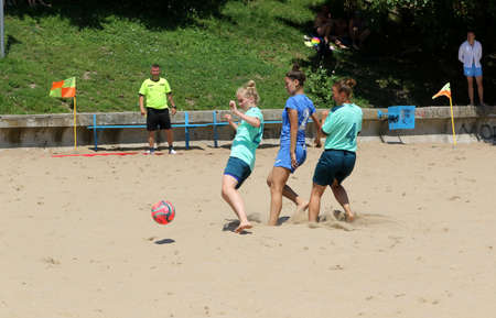 ODESSA, UKRAINE July 8, 2021: Ukrainian Beach Soccer Women's Cup. The girl's footballers are desperately playing beach soccer on sand of sea city beach on a hot sunny day. Women's soccer on sandのeditorial素材