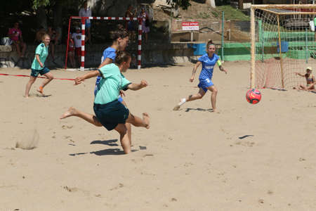 ODESSA, UKRAINE July 8, 2021: Ukrainian Beach Soccer Women's Cup. The girl's footballers are desperately playing beach soccer on sand of sea city beach on a hot sunny day. Women's soccer on sandのeditorial素材