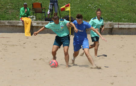 ODESSA, UKRAINE July 8, 2021: Ukrainian Beach Soccer Women's Cup. The girl's footballers are desperately playing beach soccer on sand of sea city beach on a hot sunny day. Women's soccer on sandのeditorial素材