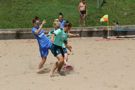 ODESSA, UKRAINE July 8, 2021: Ukrainian Beach Soccer Women's Cup. The girl's footballers are desperately playing beach soccer on sand of sea city beach on a hot sunny day. Women's soccer on sandのeditorial素材