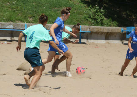 ODESSA, UKRAINE July 8, 2021: Ukrainian Beach Soccer Women's Cup. The girl's footballers are desperately playing beach soccer on sand of sea city beach on a hot sunny day. Women's soccer on sandのeditorial素材
