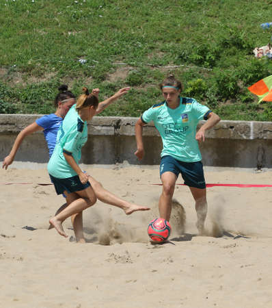 ODESSA, UKRAINE July 8, 2021: Ukrainian Beach Soccer Women's Cup. The girl's footballers are desperately playing beach soccer on sand of sea city beach on a hot sunny day. Women's soccer on sandのeditorial素材