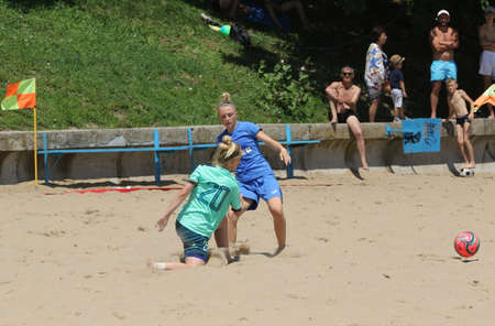 ODESSA, UKRAINE July 8, 2021: Ukrainian Beach Soccer Women's Cup. The girl's footballers are desperately playing beach soccer on sand of sea city beach on a hot sunny day. Women's soccer on sandのeditorial素材