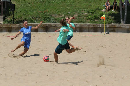 ODESSA, UKRAINE July 8, 2021: Ukrainian Beach Soccer Women's Cup. The girl's footballers are desperately playing beach soccer on sand of sea city beach on a hot sunny day. Women's soccer on sandのeditorial素材