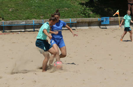 ODESSA, UKRAINE July 8, 2021: Ukrainian Beach Soccer Women's Cup. The girl's footballers are desperately playing beach soccer on sand of sea city beach on a hot sunny day. Women's soccer on sandのeditorial素材